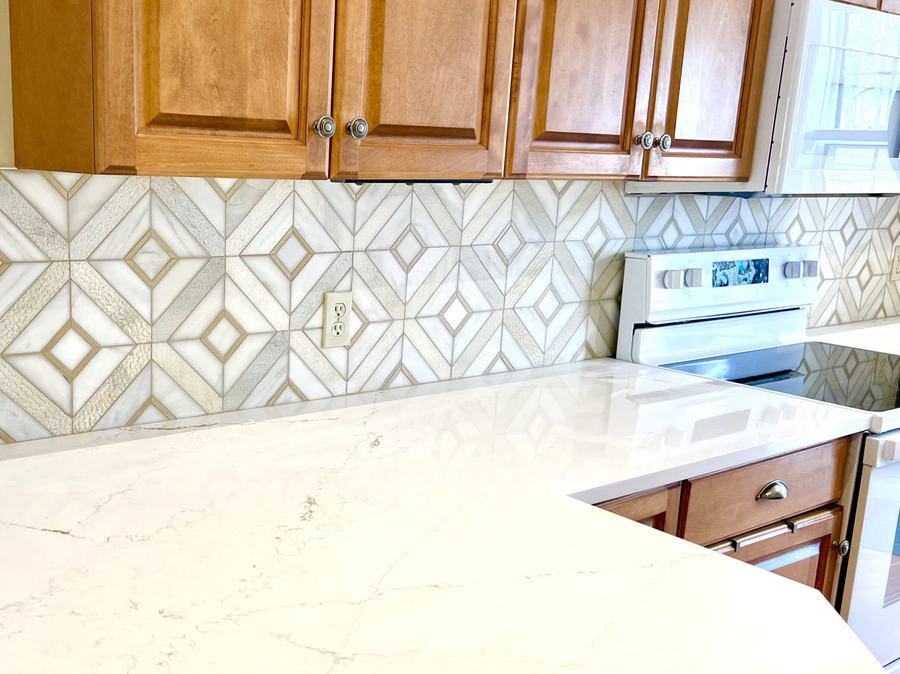 Hexagon tile backsplash above a quartz counter with wood cabinets