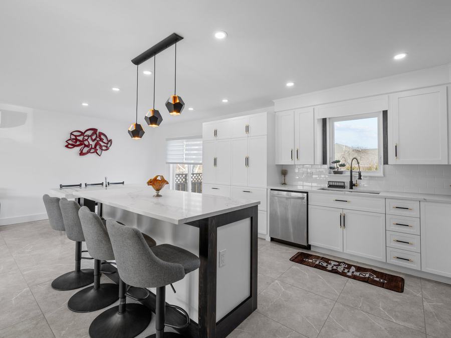 Grey large-format tile floor in a finished kitchen with an island