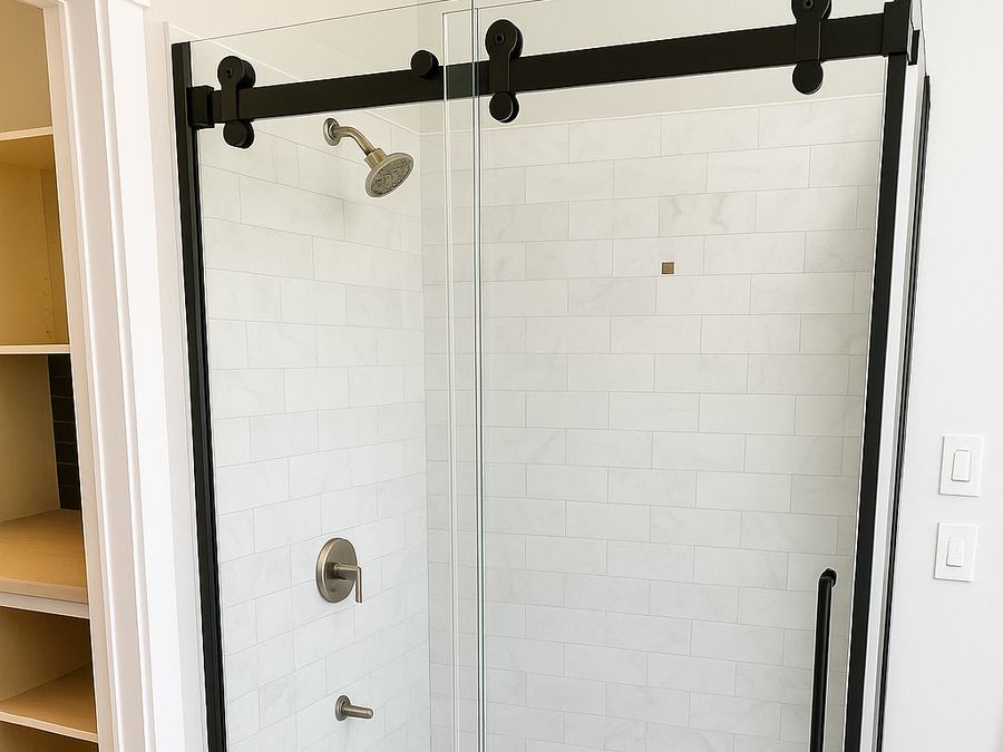 Tiled shower with a black frameless sliding glass door