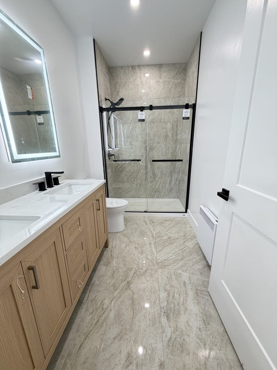 Shower tile and a sliding glass shower door, by High-5 Renovations
