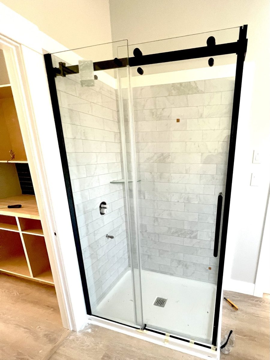 A sliding glass shower door fitted by High-5 Renovations