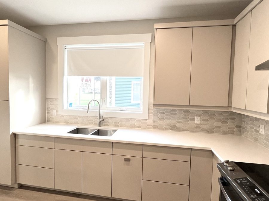A kitchen with a hexagon tile backsplash by High-5 Renovations