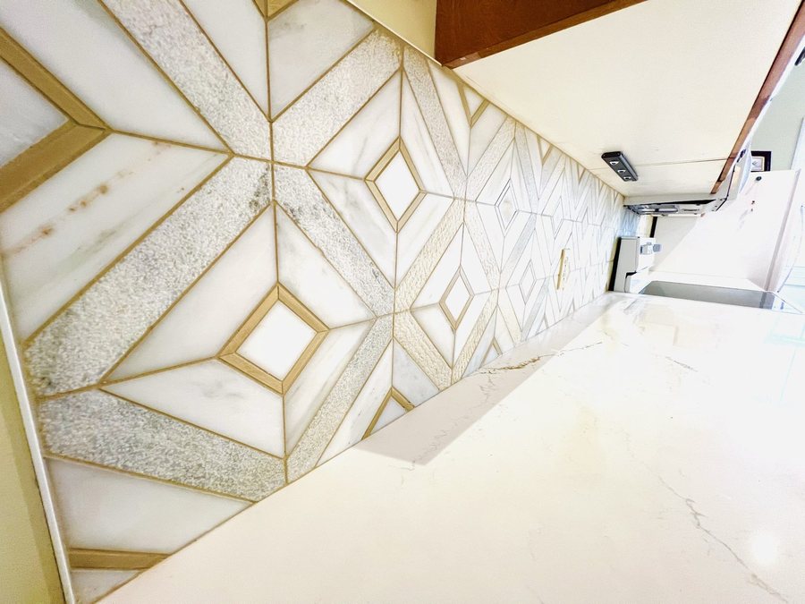 A gold and marble patterned backsplash by High-5 Renovations